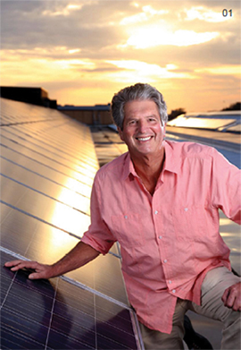 Scientia Professor Martin Green AM poses with solar panels on a rooftop at the UNSW